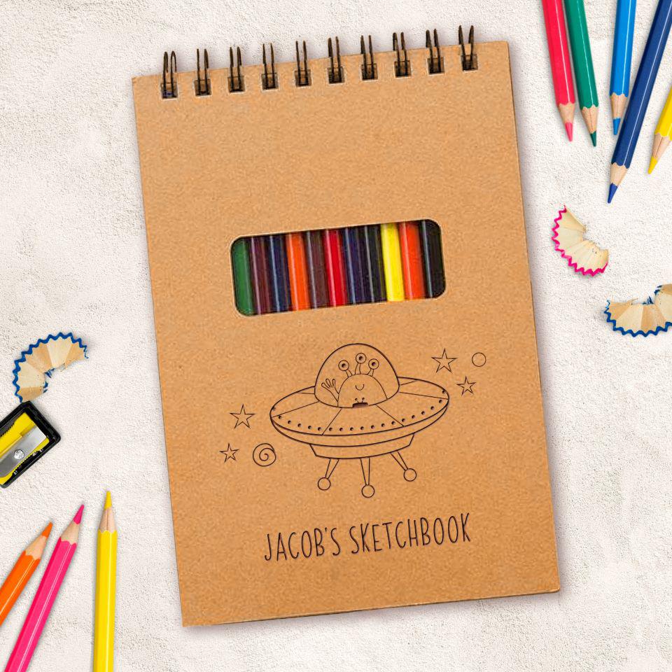 https://www.agiftpersonalized.com/cdn/shop/products/staged_sketchPadwithpencils_qual1778_alienspaceship_jacobssketchbook_1800x1800.jpg?v=1682058125